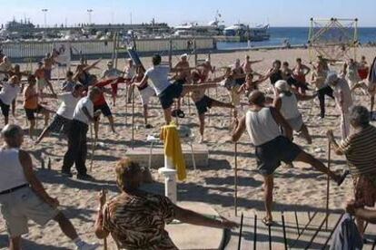 Un grupo de ancianos practica gimnasia en la playa de Benidorm.