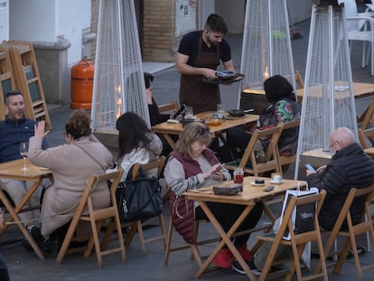 Un camarero atiende las mesas de una terraza en Sevilla.