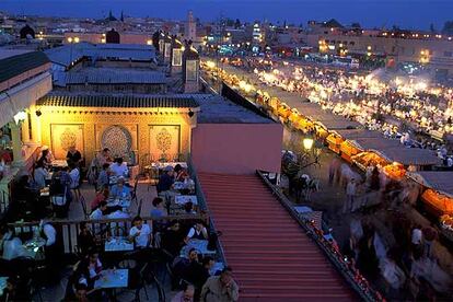 La plaza de Yemaa el Fna se ilumina al anochecer con sus terrazas y decenas de puestos callejeros donde se puede cenar a bajo precio.