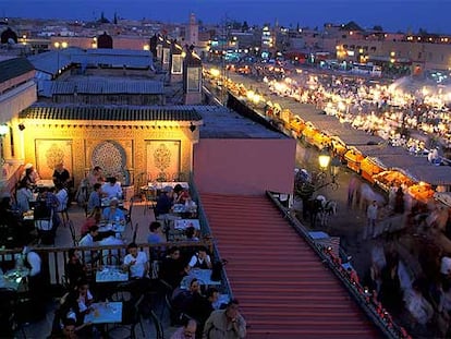 La plaza de Yemaa el Fna se ilumina al anochecer con sus terrazas y decenas de puestos callejeros donde se puede cenar a bajo precio.