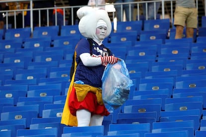 Aficionados japoneses limpian la grada tras el partido Bélgica-Japón.