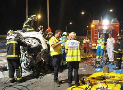 Momento en que los bomberos rescatan a los ocupantes de uno de los vehículos implicados en el siniestro.