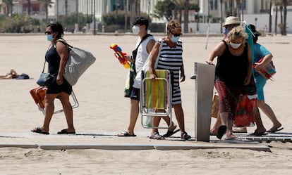 A group of people wear face masks in Malvarrosa beach in Valencia.