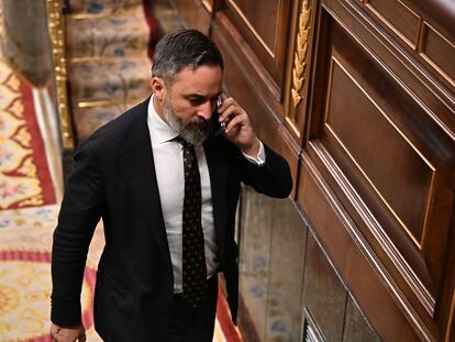 El líder de Vox, Santiago Abascal, atiende una llamada mientras abandona el hemiciclo durante el pleno del Congreso, este jueves.