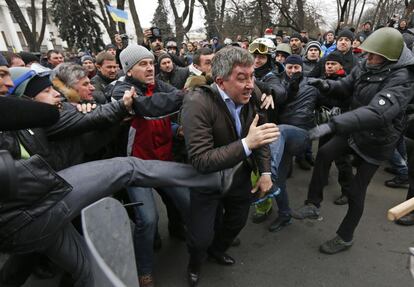 Manifestantes antigubernamentales atacan a un diputado del Partido de las Regiones, Vitaly Grushevsky, en el exterior del edificio del Parlamento de Ucrania en Kiev 22 de febrero 2014.