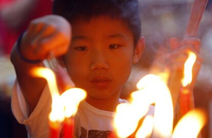 Un niño de origen chino enciende velas y varillas de incienso en el primer día del Año Nuevo Lunar chino en un templo de Kuala Lumpur, Malasia.