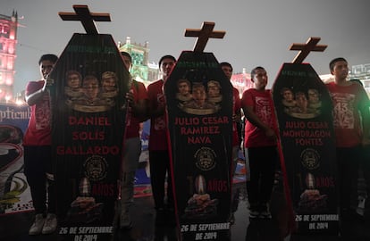 Bajo la lluvia, estudiantes marcharon con féretros de cartón con los nombres y retratos de los 43 estudiantes desaparecidos, este jueves en Ciudad de México. 