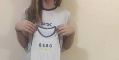 Lara segura o uniforme.