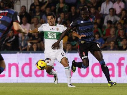 Nyom pelea un bal&oacute;n con Mantec&oacute;n, del Elche.  