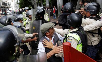 Partidarios del gobierno de Nicolás Maduro chocan con la policía antidisturbios mientras los partidarios de la oposición protestan, en Caracas.