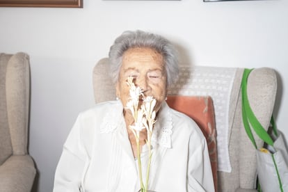 Rafaela, oliendo unas flores en el salón de su casa de Córdoba.
