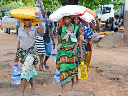 Varias personas recogen ayuda humanitaria tras el paso del ciclón en Beira (Mozambique).