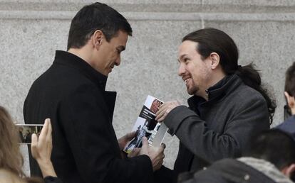 El líder de Podemos, Pablo Iglesias (d), obsequia al secretario general del PSOE, Pedro Sánchez, con el libro "Historia del Baloncesto de España".