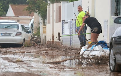 Una pareja limpia la entrada de su vivienda tras las lluvias torrenciales en San Javier (Murcia), este sábado.