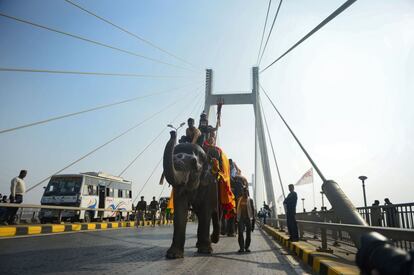 Hindús montan en un elefante mientras participan en una procesión religiosa hacia el área de Sangam durante la primera 'entrada real' para el Kumbh Mela, en Allahabad (India).