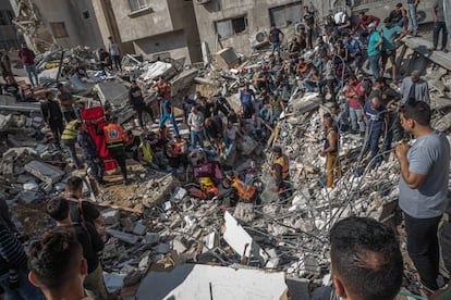 Personal de emergencias y voluntarios buscan supervivientes en un edificio destruido durante un bombardeo en Gaza, este domingo. La operación, que de acuerdo con un portavoz del Ejército israelí iba dirigida contra la sede del centro de inteligencia de Hamás en el norte de la Franja, ha arrasado tres edificios.