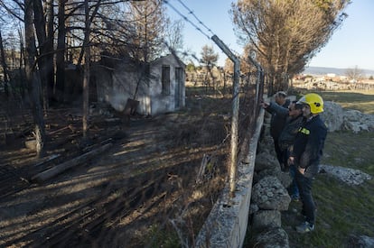 El ganadero Jesús Baterna, de Robledillo, enseña a los bomberos Juan Carlos Prieto y Juan Ignacio García, una caseta que arrasó el incendio.