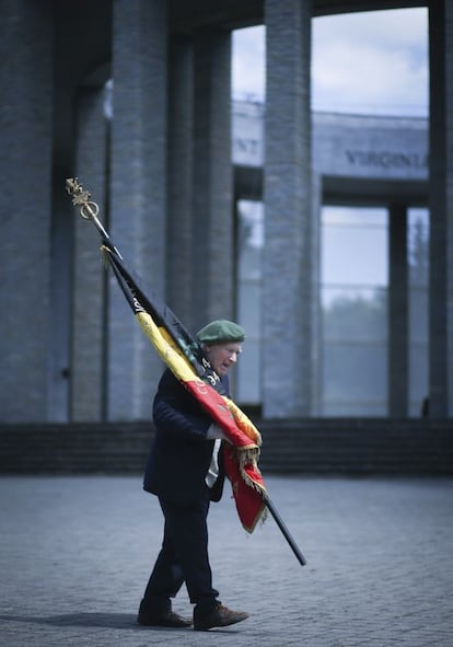 Un veterano belga porta la bandera de su país a la llegada de la ceremonia para conmemorar el 70º aniversario de la batalla de Adrenne durante la Segunda Guerra Mundial, en el monumento Mardason, en Bastogne, al sur de Bélgica.