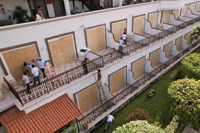 Trabajadores de un hotel instalan tablones de madera para proteger ventanales, el 3 de julio en Playa del Carmen.