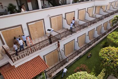 Trabajadores de un hotel instalan tablones de madera para proteger ventanales, el 3 de julio en Playa del Carmen.