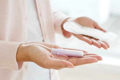 Woman holding sanitary towel and tampon