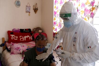 Un médico voluntario revisa a una enferma de covid, en febrero en Jalisco.