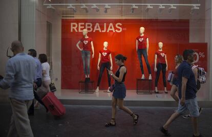 Varias personas pasan ante una tienda con rebajas en Sevilla