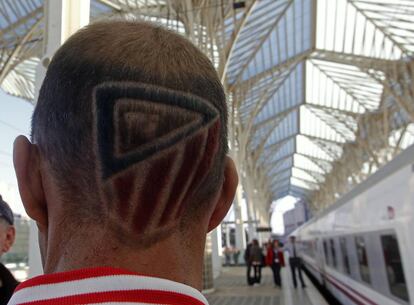 Un aficionado del Atlético, con el escudo de su equipo en la cabellera, camino de Lisboa.