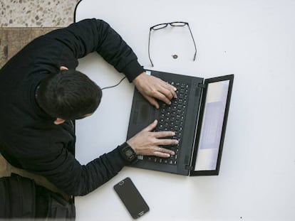 Un hombre navega por internet en su portátil.