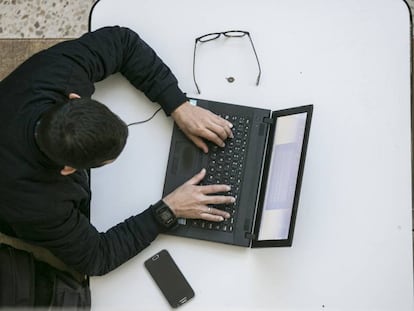 Un alumno con su portátil y su móvil en la Universidad Autónoma de Madrid.