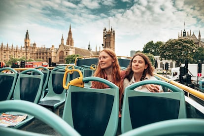 Dos amigas viajan por las calles de Londres en un autobús turístico de dos plantas.