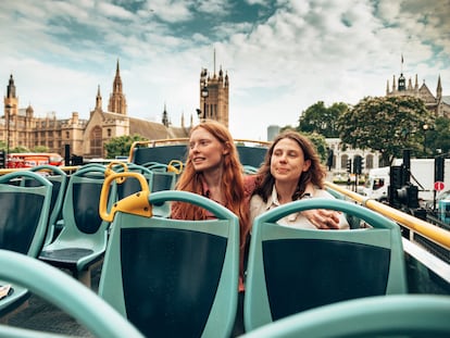 Dos amigas viajan por las calles de Londres en un autobús turístico de dos plantas.