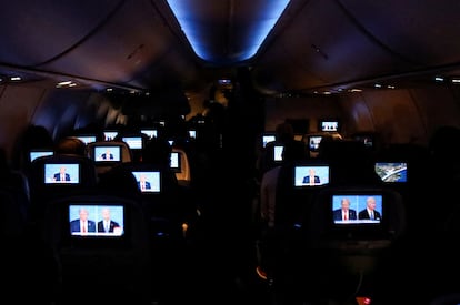 Passengers watch the presidential debate on board a flight to Miami, Florida.