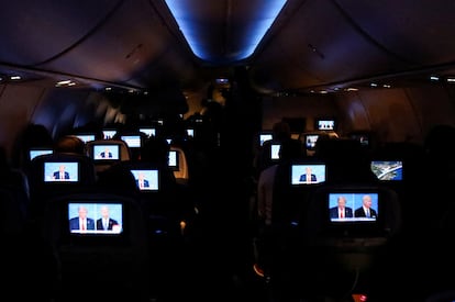 Pasajeros siguen el debate presidencial abordo de un vuelo hacia Miami (Florida).