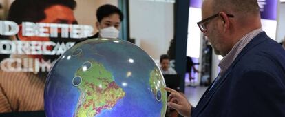 Un visitante contempla un globo terráqueo en la cumbre del clima COP27, celebrada en Egipto.