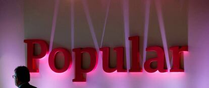 Un hombre pasando cerca del logotipo de Banco Popular