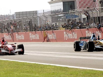 Fernando Alonso (a la derecha) levanta su brazo izquierdo para festejar su segundo puesto, por delante de Michael Schumacher.