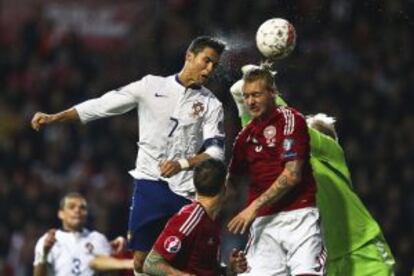 Cristiano Ronaldo, anotando su gol de cabeza ante el defensa Simon Kjaer de Dinamarca.