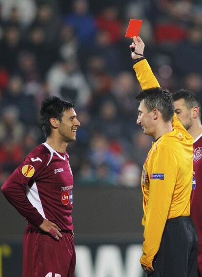 El árbitro muestra la tarjeya roja al jugador del Cluj Camora.