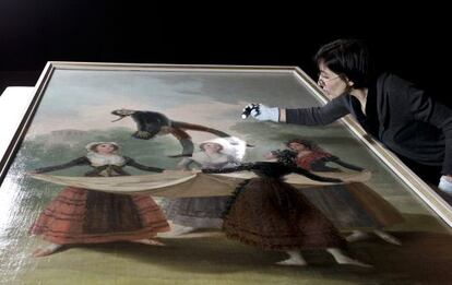 A conservationist inspects the Goya painting El Pelele before it was hung for the CaixaForum exhibition in Barcelona.