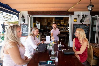 Tim Zonneveld sirve a varios turistas en la terraza del bar Euro Café de La Carihuela.