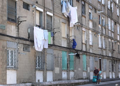 Dos personas pasean frente a un edificio sin aire acondicionado, durante la ola de calor del mes de julio en San Cristóbal de los Ángeles, Madrid.