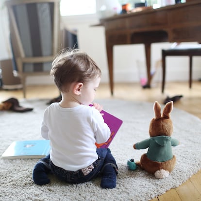 A boy reading a book to his rabbit
