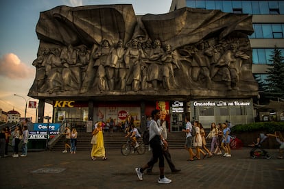 El comunismo y el capitalismo se abrazan en Minsk, la capital bielorrusa. Un restaurante de comida rápida bajo un mural de la época soviética. 