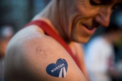 Detalhe da tatuagem no braço de um atleta que se prepara para correr a maratona em Boston.