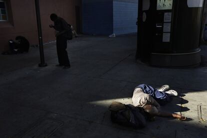 Um mendigo dorme no chão em uma rua de Skid Row. Milhares de indigentes pernoitam a cada dia em suas ruas; os mais afortunados conseguem uma cama oferecida por associações caridosas, mas a maioria acaba dormindo na rua.