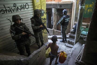 La policía militar del ejército brasileño patrulla a lo largo de un callejón en la favela de Rocinha, en Río de Janeiro (Brasil). Funcionarios de seguridad aseguran que la favela Rocinha vuelve a estar bajo control después de que cientos de soldados y policías fueran enviados a combatir traficantes de drogas armados.