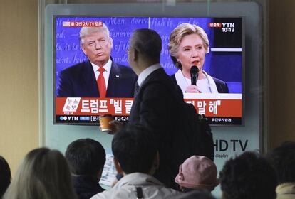 Varias personas miran en una pantalla el debate en directo entre Hillary Clinton y Donald Trump en la estación de tren de Seúl (Corea del Sur).
