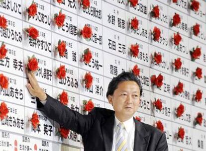 Yukio Hatoyama, líder del Partido Democrático de Japón (PDJ), pone una flor en el nombre de un diputado de su partido al obtener un escaño en el Congreso. El PDJ ha sido el gran vencedor de las elecciones legistalivas celebradas este domingo con 308 escaños de los 480 que tiene la Cámara.