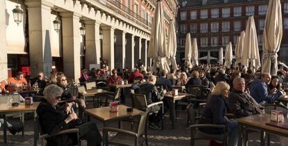 Un grupo de turistas sentados en una terraza de la Plaza Mayor, en pleno centro de Madrid. 